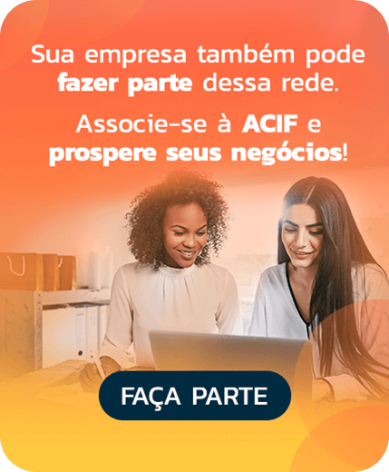 pagina sobre a acif - duas mulheres olhando o computador, imagem com filtro laranja. CTA chamando para se associar