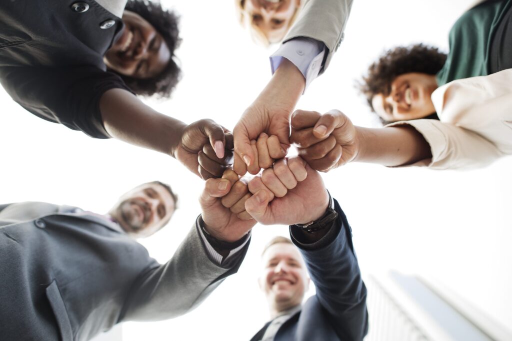 equipe de colaboradores motivados reunidos em um círculo e se cumprimentando com um soquinho de mão